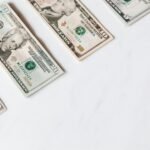 US dollar banknotes arranged on a clean white surface, showcasing different denominations.